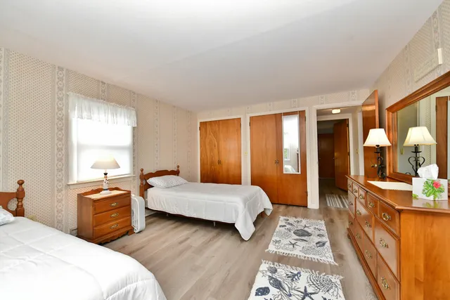 a bedroom with two beds and a dresser