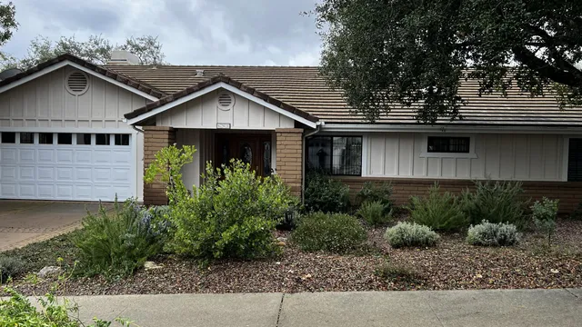 a view of a house with a yard and potted plants