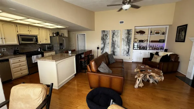 a living room with furniture a flat screen tv and kitchen view
