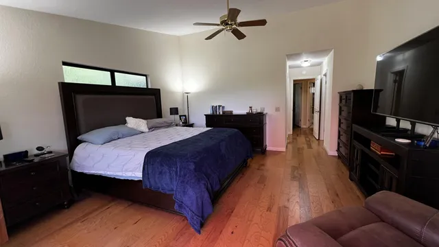 a spacious bedroom with a bed and a flat screen tv