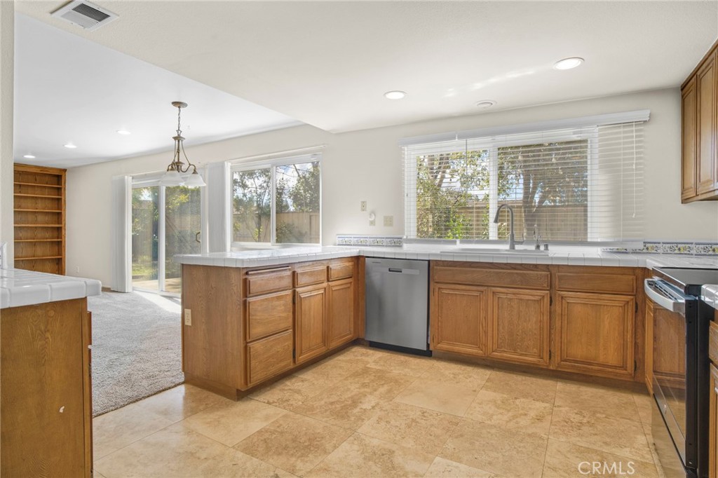 3488 Radcliffe Road Thousand Oaks, CA 91360 - Photo 9 of 23 a large kitchen with kitchen island granite countertop a stove a sink dishwasher and a large refrigerator