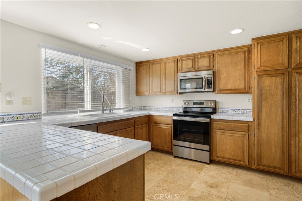 3488 Radcliffe Road Thousand Oaks, CA 91360 - Photo 10 of 23 a kitchen with stainless steel appliances granite countertop a stove a sink and a refrigerator