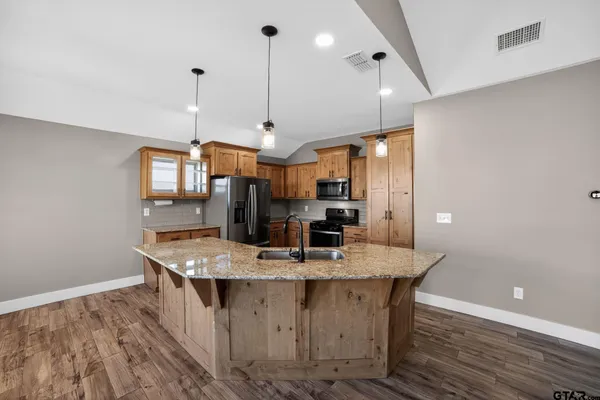 a kitchen with stainless steel appliances kitchen island a wooden floor
