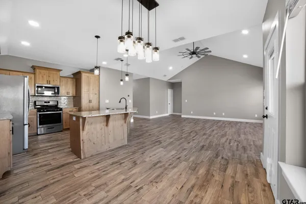 an open kitchen with wooden floor and large kitchen view
