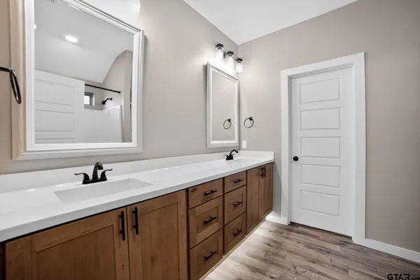 a bathroom with a double vanity sink a mirror and a bathtub