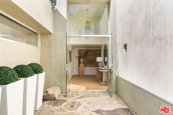 a view of a hallway with wooden floor and a living room