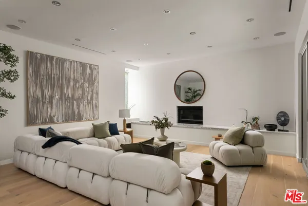 a living room with furniture a large window and a clock