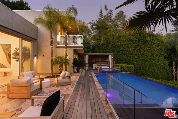 a living room with patio furniture and a potted plant
