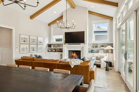 a living room with fireplace furniture and a large window