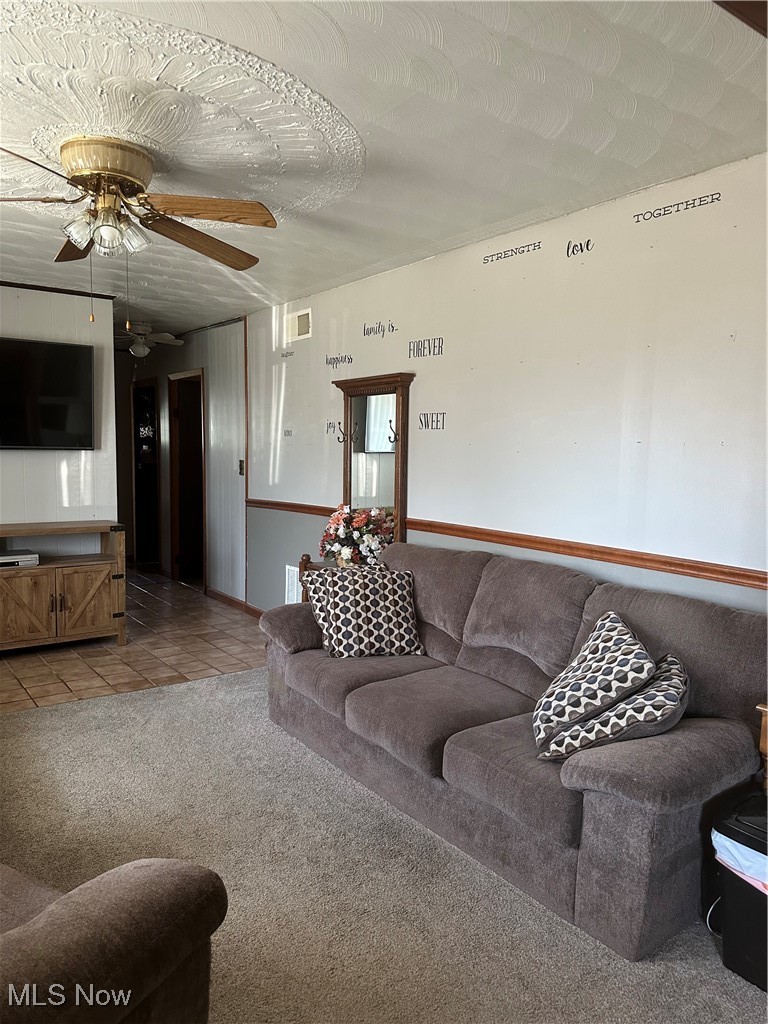 167 Andover Road Woodsfield, OH 43793 - Photo 44 of 50 Living room with light colored carpet, visible vents, a ceiling fan, light tile patterned flooring, and a textured ceiling