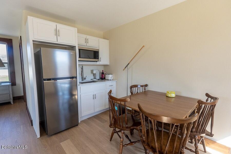 10 Goodell Road Lanesborough, MA 01237 - Photo 28 of 67 a kitchen with stainless steel appliances granite countertop a dining table chairs refrigerator and sink