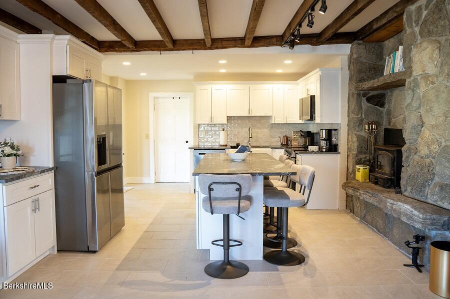 10 Goodell Road Lanesborough, MA 01237 - Photo 7 of 67 a kitchen with stainless steel appliances kitchen island granite countertop a table chairs in it and wooden floors