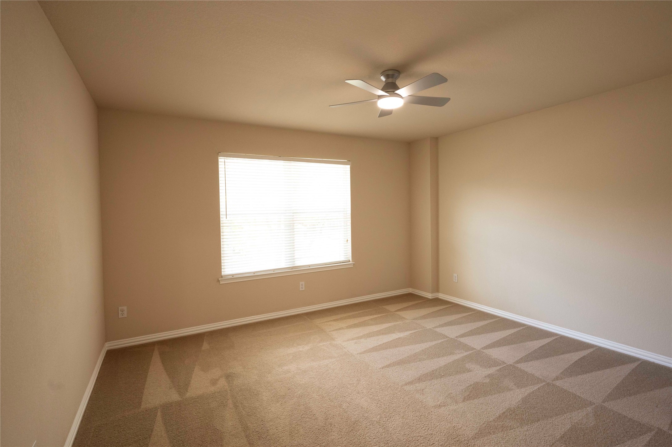 2070 Intrepid Drive Buda, TX 78610 - Photo 21 of 31 A well-lit bedroom features plush carpet flooring and a ceiling fan for comfort.