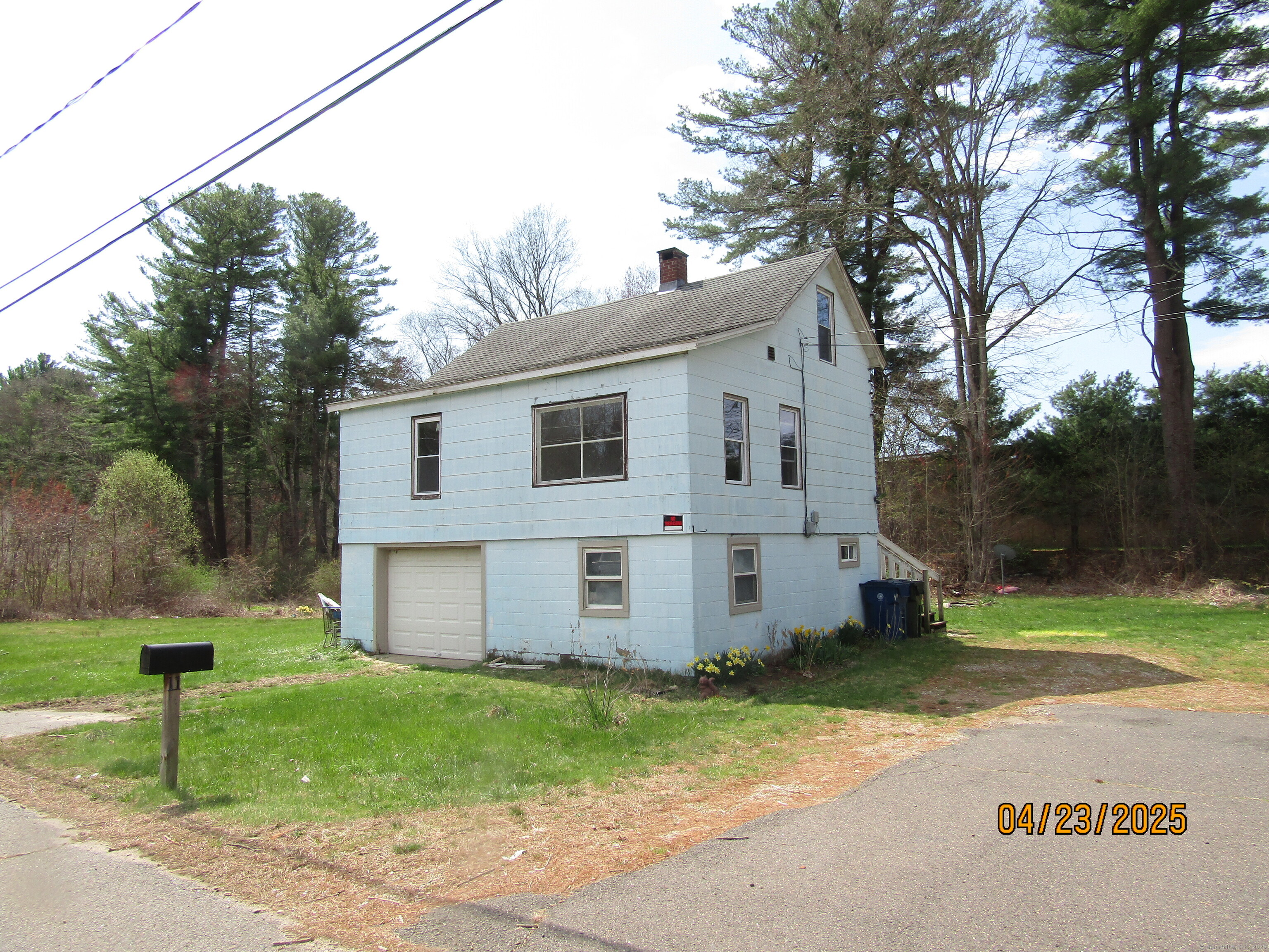 a view of a white house with a big yard and large tree