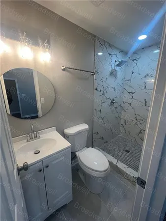 a bathroom with a toilet a sink a shower and mirror