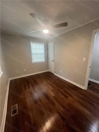 a view of an empty room with wooden floor