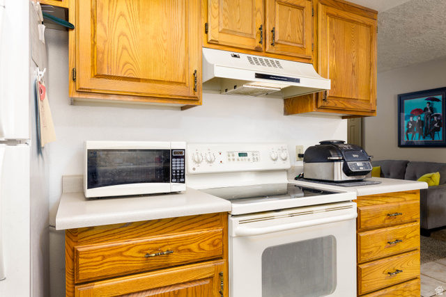 3707 Gates Circle Santa Clara, UT 84765 - Photo 10 of 19 Kitchen featuring white appliances, light countertops, wood finish cabinetry, and a textured ceiling