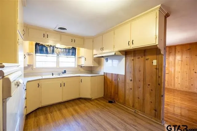 a kitchen with cabinets a sink and wooden floor