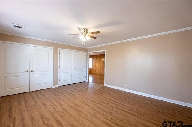 a view of an empty room with wooden floor