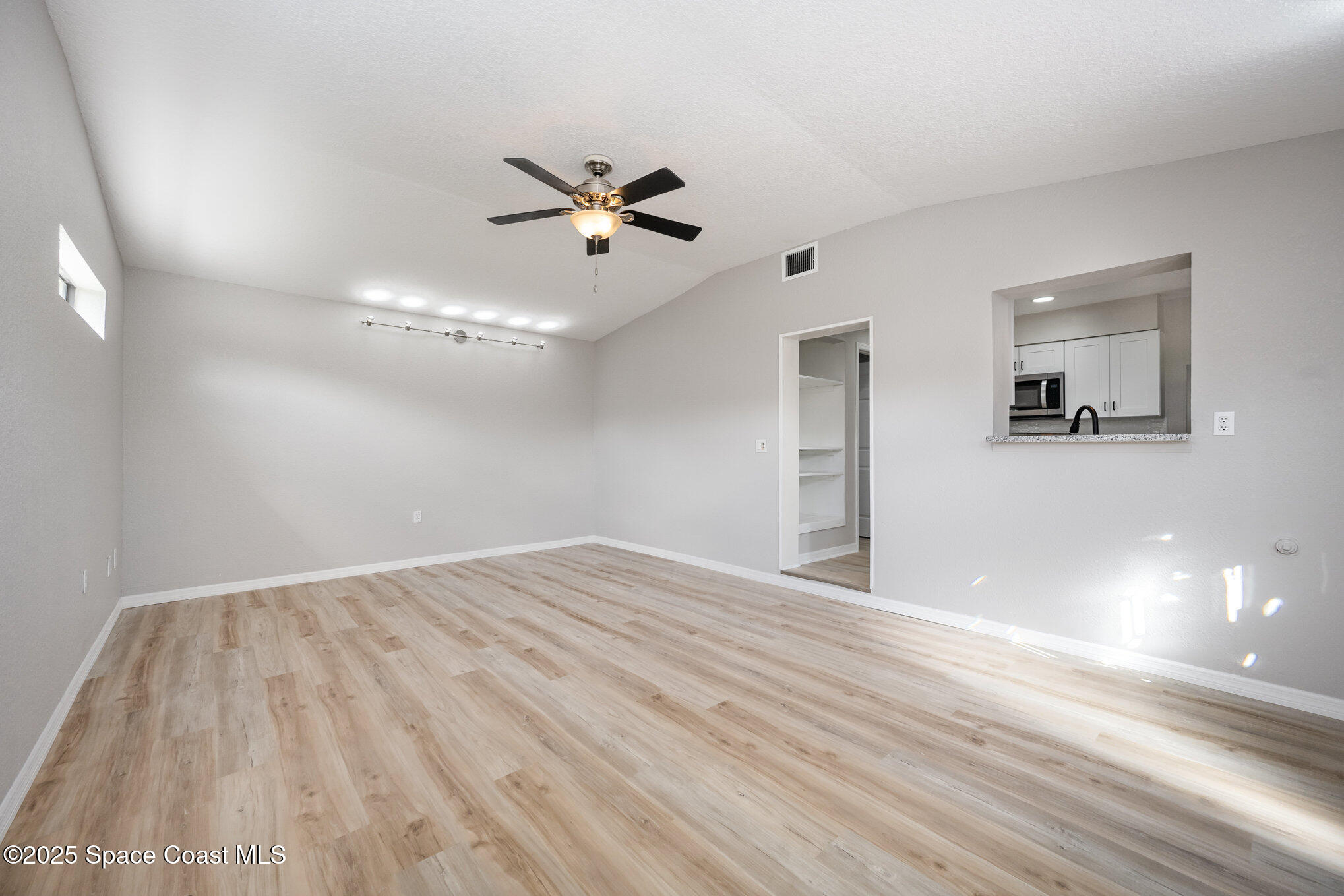 980 Miracle Way Rockledge, FL 32955 - Photo 13 of 33 a view of empty room with wooden floor and ceiling fan