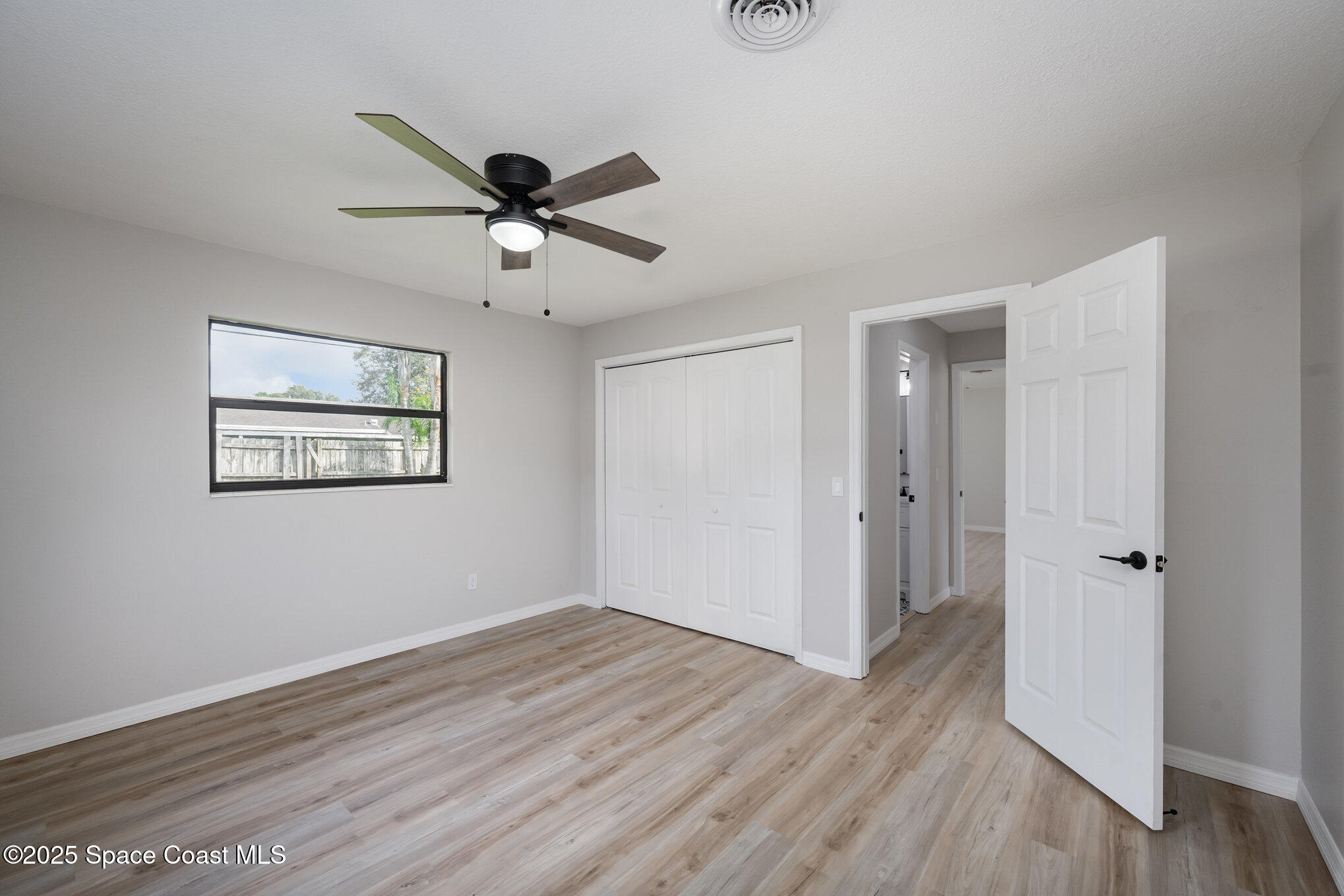 980 Miracle Way Rockledge, FL 32955 - Photo 17 of 33 a view of a hallway with wooden floor and a chandelier fan