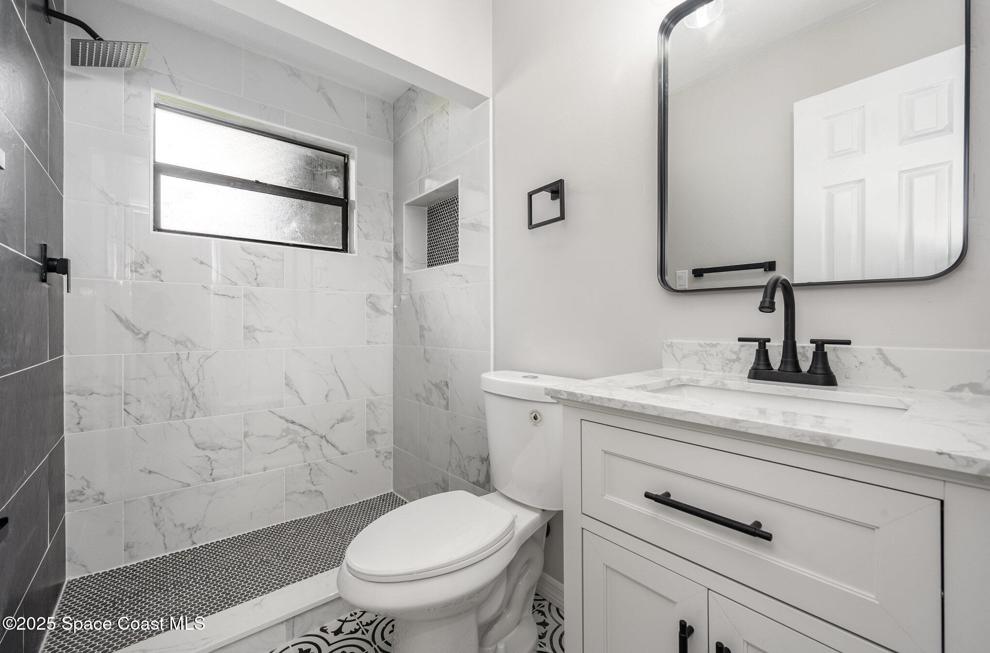 980 Miracle Way Rockledge, FL 32955 - Photo 18 of 33 a bathroom with a granite countertop toilet sink and mirror