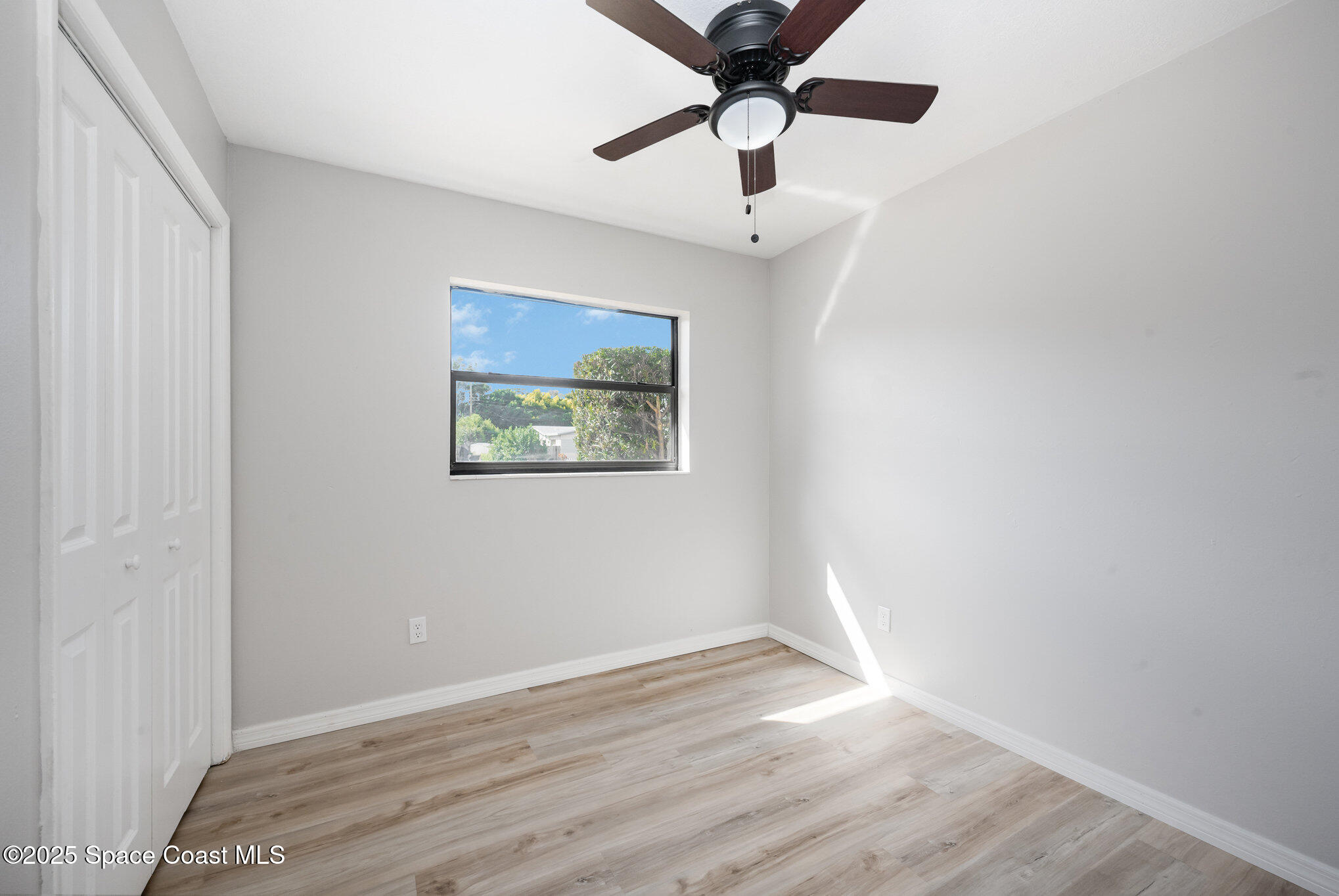 980 Miracle Way Rockledge, FL 32955 - Photo 23 of 33 an empty room with wooden floor and ceiling fan