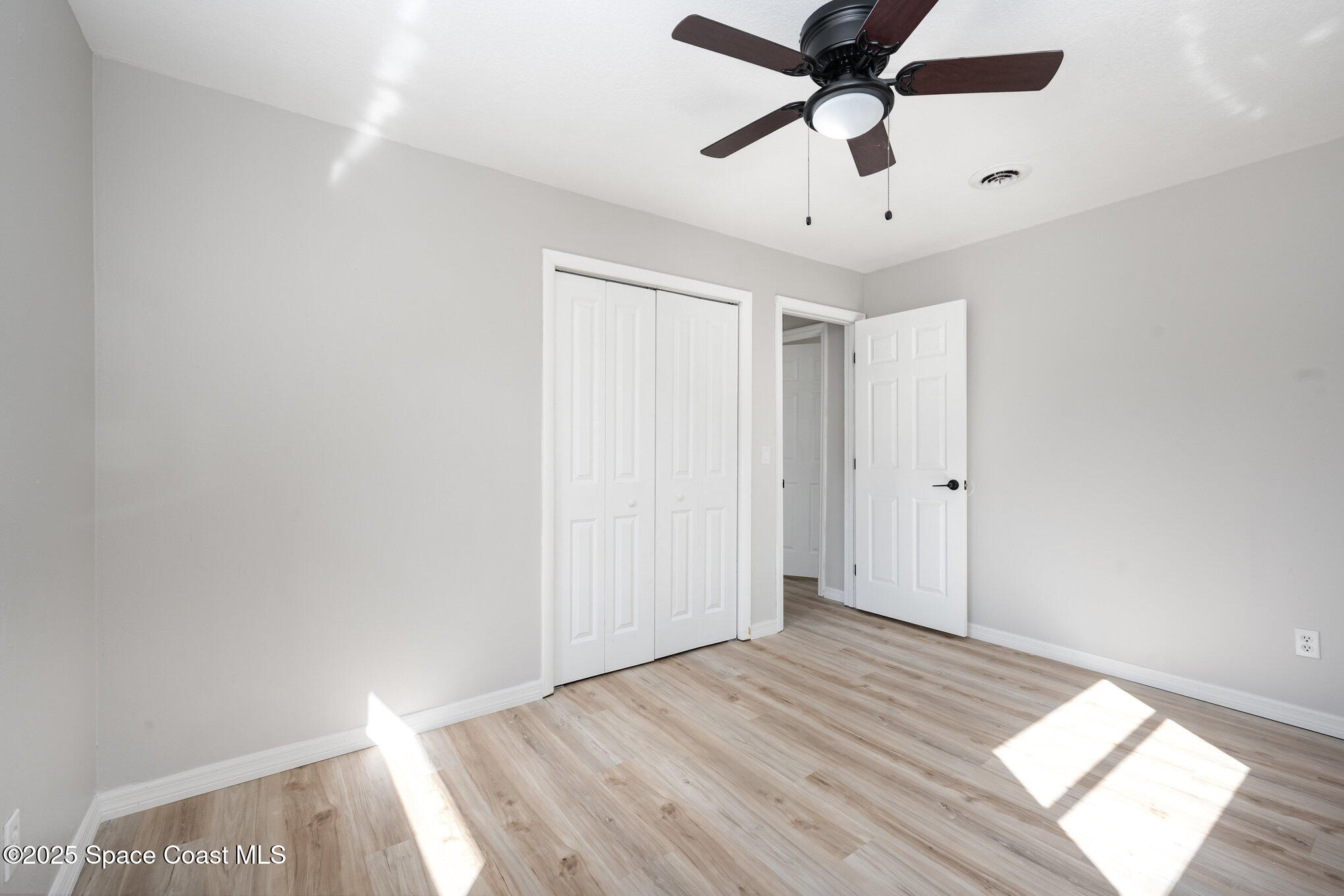 980 Miracle Way Rockledge, FL 32955 - Photo 27 of 33 a view of empty room with wooden floor and fan