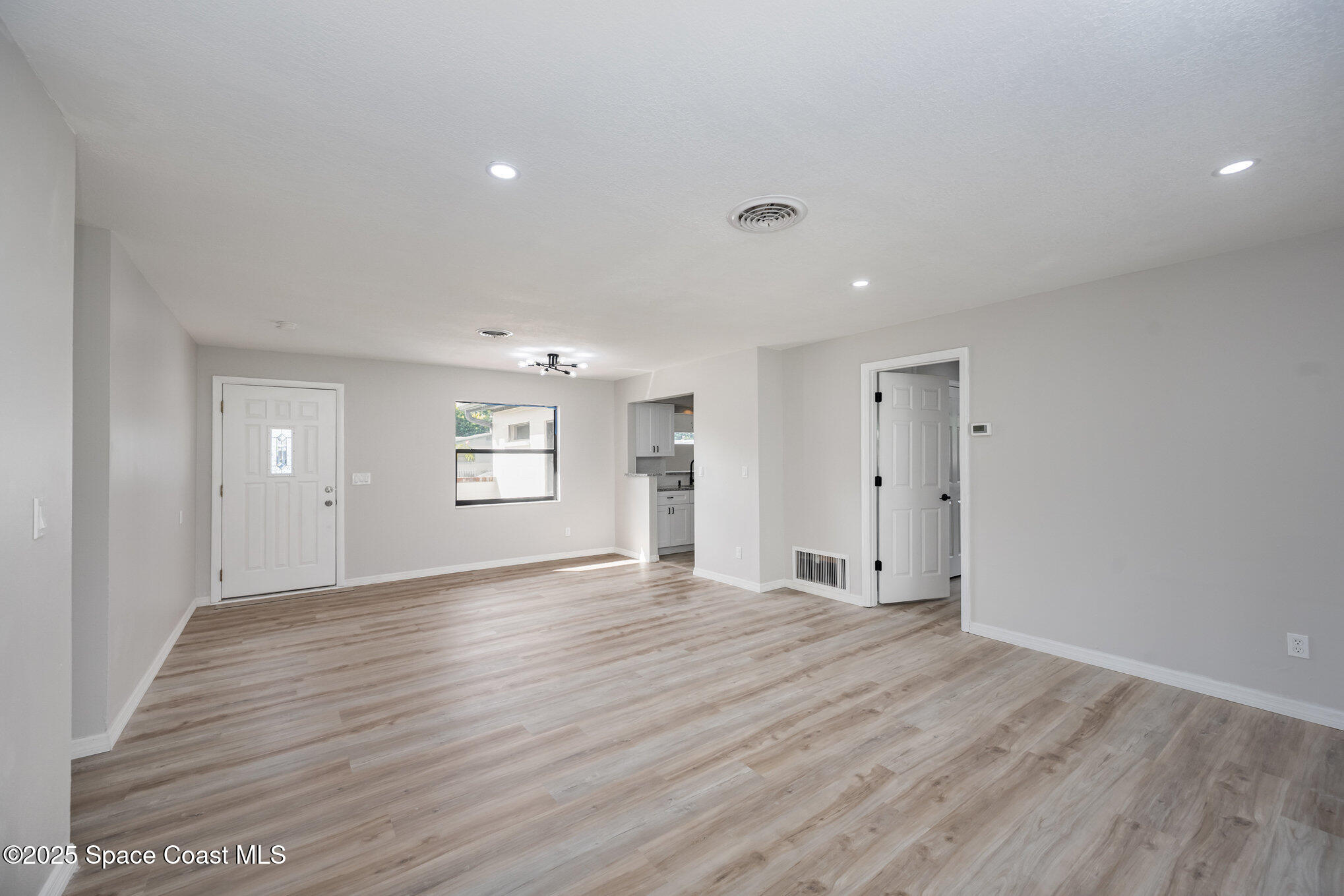980 Miracle Way Rockledge, FL 32955 - Photo 7 of 33 a view of an empty room with wooden floor and windows