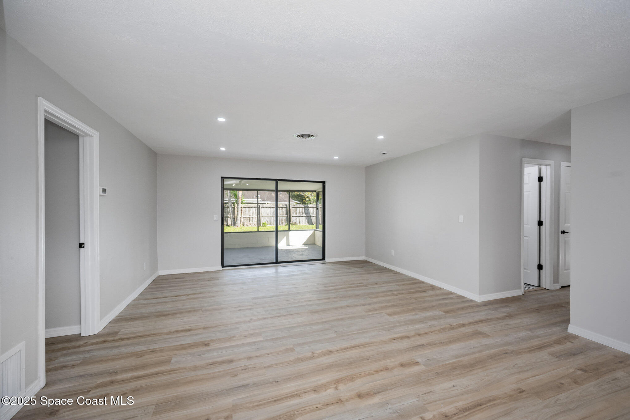 980 Miracle Way Rockledge, FL 32955 - Photo 8 of 33 a view of an empty room with wooden floor and a window