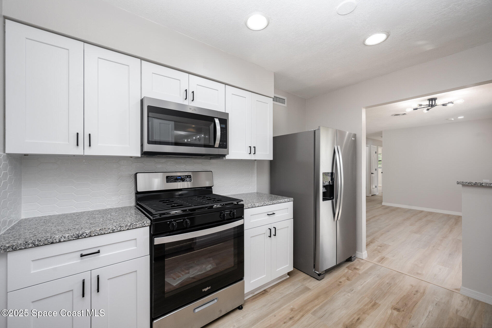 980 Miracle Way Rockledge, FL 32955 - Photo 9 of 33 a kitchen with granite countertop a refrigerator stove and microwave