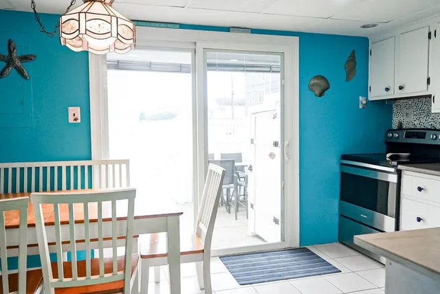 a kitchen with granite countertop a stove a refrigerator and a white cabinets