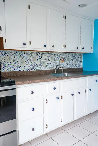 a kitchen with white cabinets and white appliances