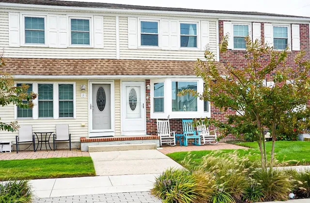 a front view of a house with a yard and outdoor seating