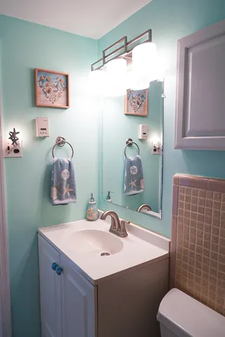 a bathroom with a sink mirror and toilet