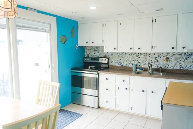 a kitchen with granite countertop white cabinets and stainless steel appliances