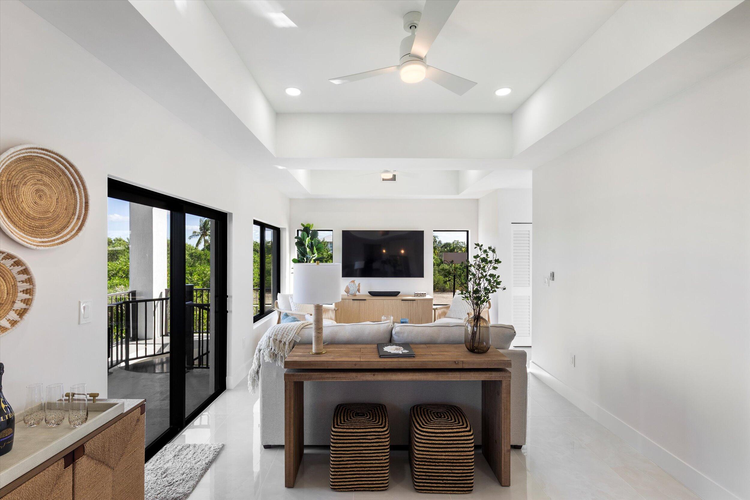 27433 Antigua Road Summerland Key, FL 33042 - Photo 23 of 64 a living room with furniture a flat screen tv and a fireplace