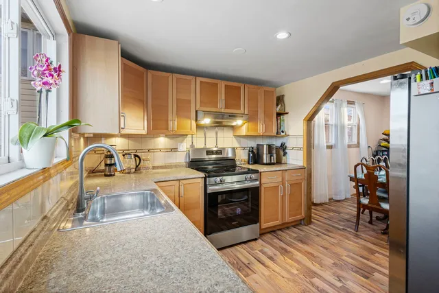 a kitchen with stainless steel appliances granite countertop a stove a sink and a refrigerator