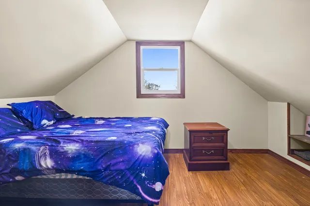 a view of a bedroom with furniture and wooden floor