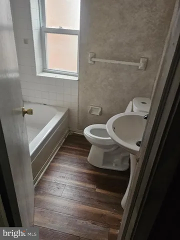 a view of a white house with a big yard and potted plants