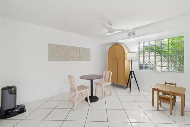 a kitchen with stainless steel appliances a stove top oven a sink a dining table and chairs