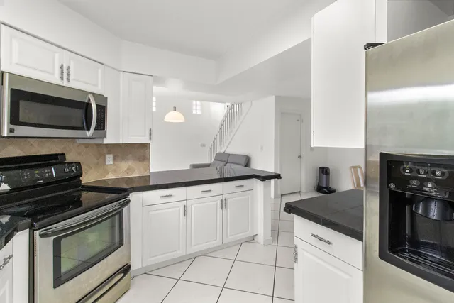 a kitchen with stainless steel appliances granite countertop a refrigerator and a sink
