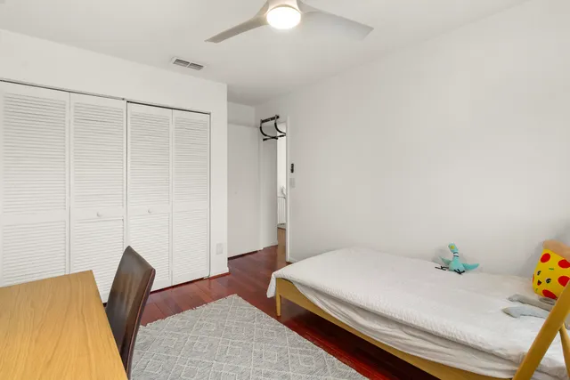 a room with a bed and hardwood floor