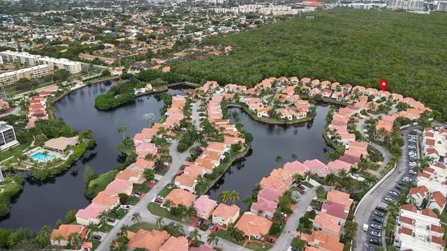 an aerial view of a residential houses with outdoor space and trees