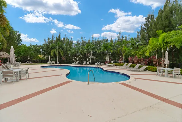 a view of a swimming pool with a lawn chairs under an umbrella