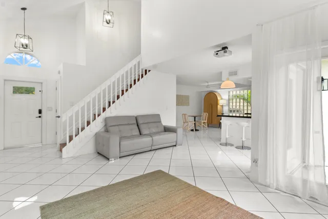 a view of an empty room with stairs and a rug