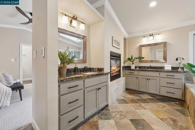 a bathroom with a granite countertop sink vanity mirror next to a window