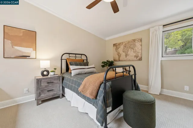 a bedroom with a bed a mirror on dresser and a window