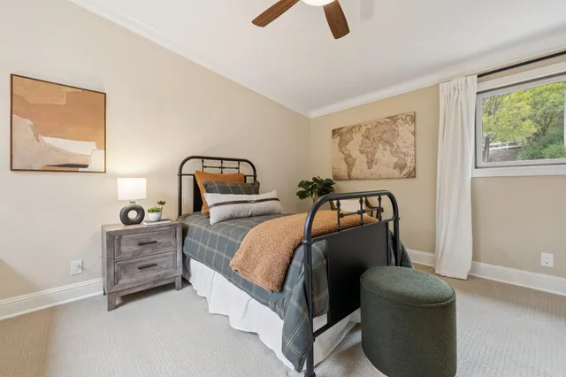 a bedroom with a bed a mirror on dresser and a window