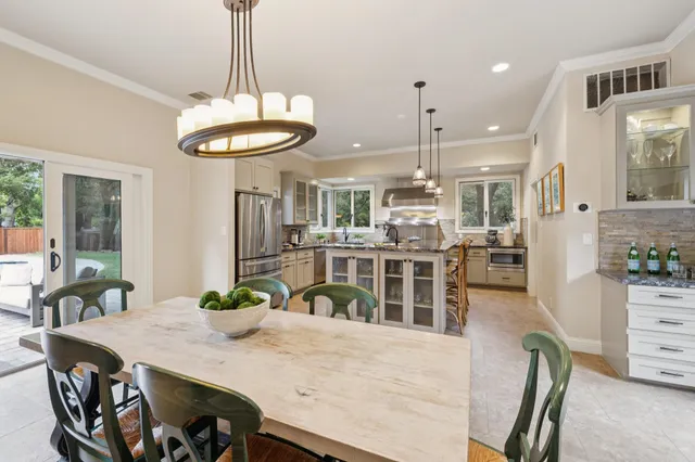 a close view of a stove and white cabinets with wooden floor